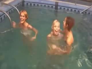 Tërheqës lezzies në the duke notuar pishinë