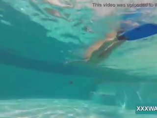 Liels brunete eskorts konfektes swims zem ūdens